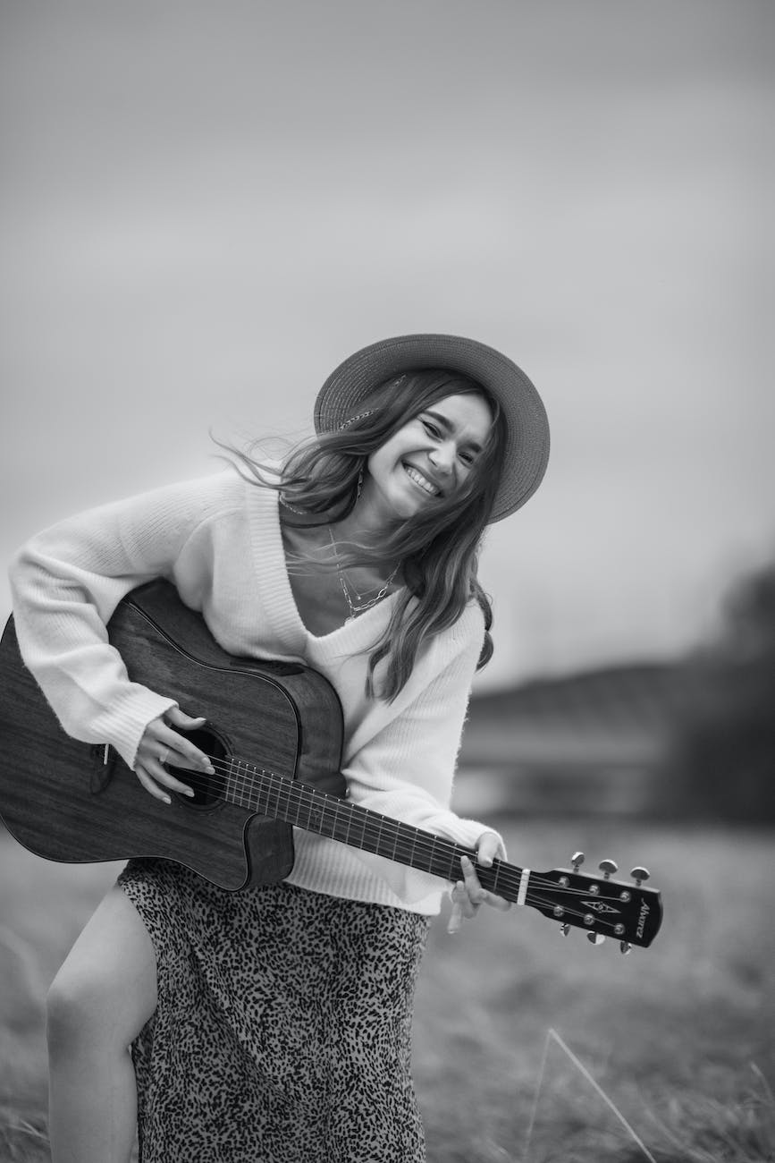 cheerful woman with guitar in black and white